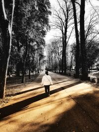 Rear view of man walking on road