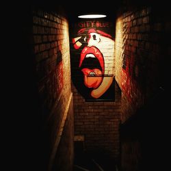 Illuminated red lantern against wall at night
