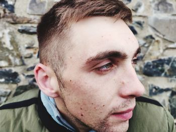 Close-up of thoughtful young man looking away outdoors