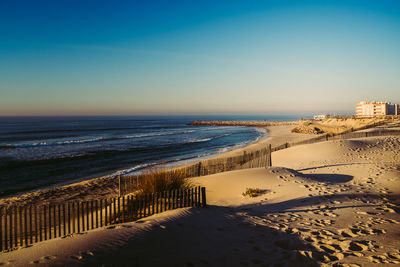 Scenic view of beach against clear blue sky