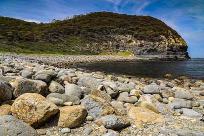 Rocks on beach against sky