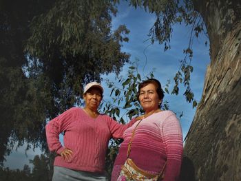 Low angle view of women standing by tree