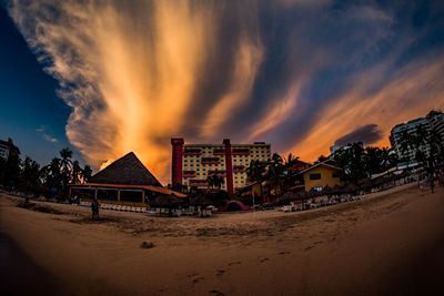 Panoramic view of beach against buildings during sunset