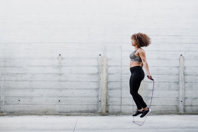 Curvy african american woman skipping rope in urban area