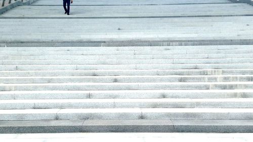 Low section of person moving down on steps