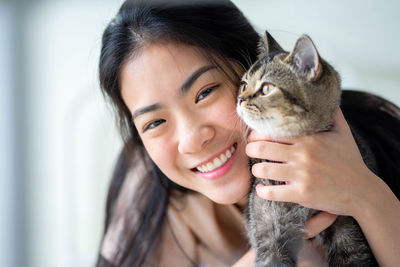 Portrait of young woman holding cat