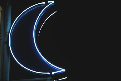 Low angle view of illuminated lighting equipment at night