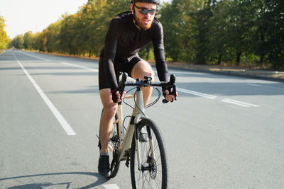 Man riding bicycle on road in city