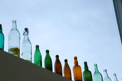 Low angle view of bottles against clear sky