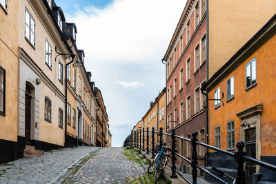 Footpath amidst buildings against sky