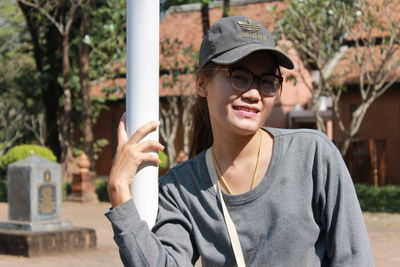 Portrait of young woman wearing sunglasses standing outdoors