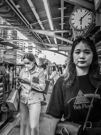 Portrait of young woman standing on railroad station