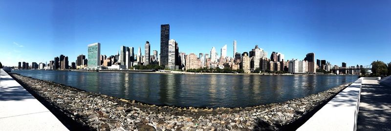 Panoramic view of city against clear blue sky