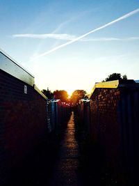 Narrow road leading towards sunset