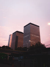 Low angle view of illuminated buildings against sky during sunset