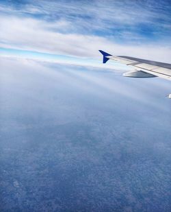 Airplane flying over cloudscape against sky