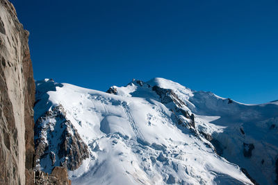 Scenic view of snowcapped mountains against clear blue sky