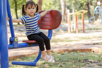 Portrait of girl sitting on outdoor play equipment