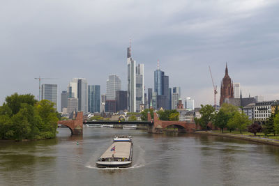 View of buildings at waterfront against cloudy sky