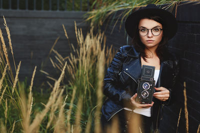 Young woman standing against plants