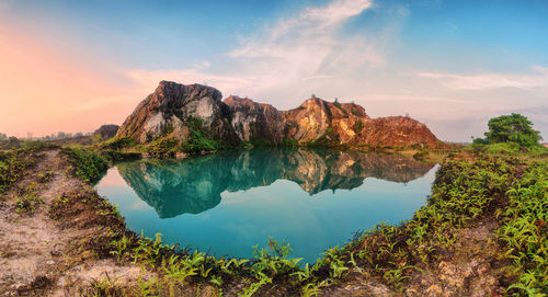 Scenic view of lake and mountains against sky during sunset