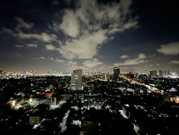 High angle view of illuminated buildings against sky at night
