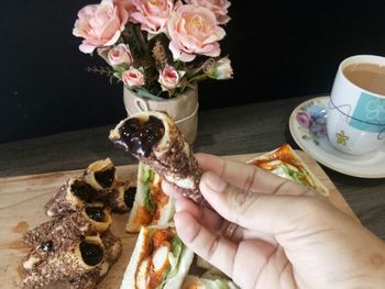 Close-up of hand holding ice cream on table