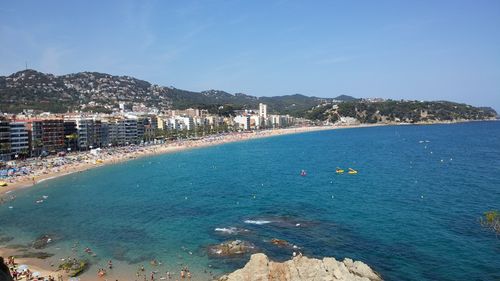 Scenic view of sea by town against clear blue sky