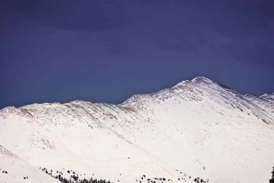 Scenic view of snowcapped mountains against blue sky