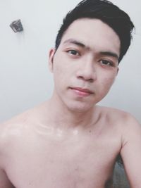 Portrait of handsome young man against wall at home