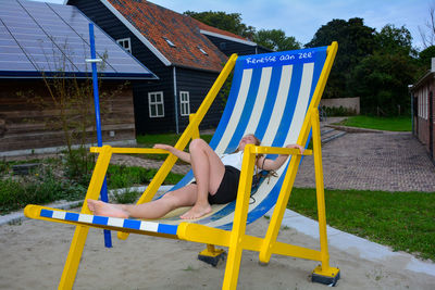 Low section of man relaxing on chair in playground