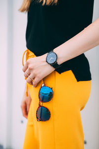 Midsection of woman holding yellow while standing outdoors