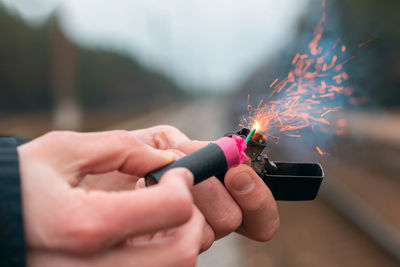 Close-up of hand holding lighter and bomb