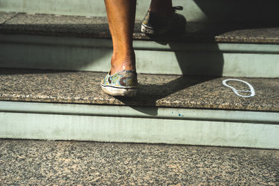 Low section of man wearing shoes on staircase