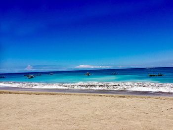 Scenic view of beach against blue sky