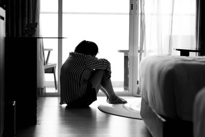 Rear view of woman looking through window