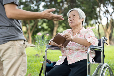 Midsection of woman with arms raised outdoors