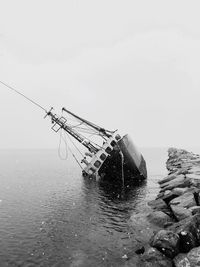 Fishing boat in sea against clear sky