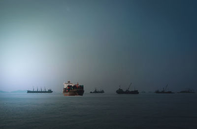 Boats sailing in sea against sky