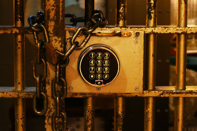 Close-up of combination lock by chain and padlock on gate