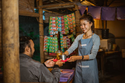 Portrait of smiling young woman standing in store