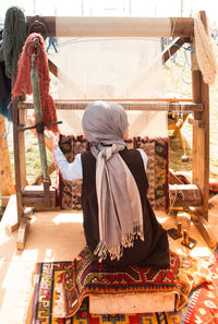 Rear view of woman sitting at temple
