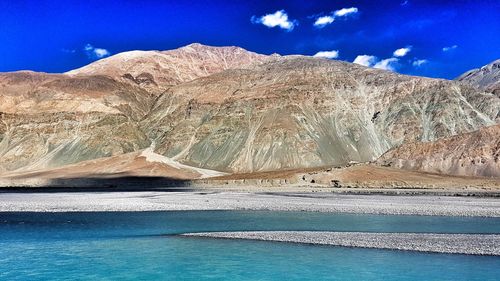 Scenic view of mountains against blue sky