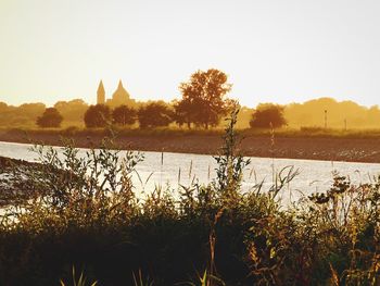 Scenic view of lake against clear sky during sunset