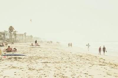 People enjoying at beach against sky