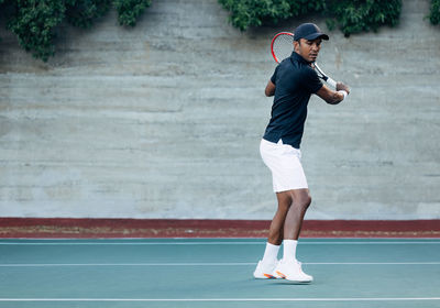 Full length of woman exercising on court