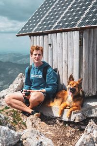 Full length of man sitting with dog