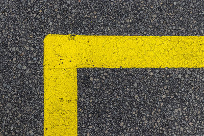 High angle view of yellow arrow symbol on road