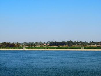 Scenic view of river against clear blue sky