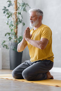 Mature man meditating at home